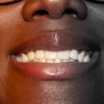 Natural Teeth Whitening Tips with a bright smile, toothbrush, whitening strips, and a clean bathroom counter