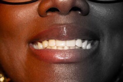 Natural Teeth Whitening Tips with a bright smile, toothbrush, whitening strips, and a clean bathroom counter
