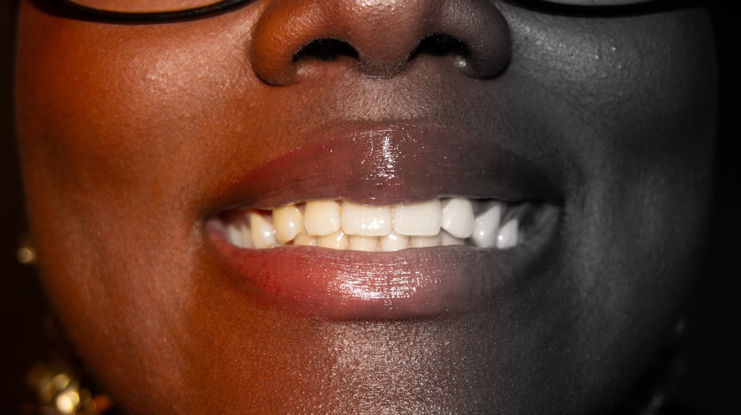 Natural Teeth Whitening Tips with a toothbrush, water glass, and bright bathroom counter