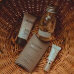 Simple Skincare Routine on a tidy bathroom counter with cleanser, moisturizer, sunscreen, and a folded towel