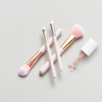 minimalist makeup routine flat lay with neutral-toned essentials